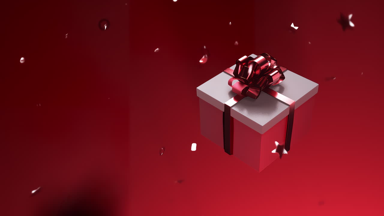 A gift with a red bow is spinning on a red background with falling confetti