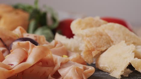 ham italian mordatella, man slices of traditional italian antipasti mortadella sausage on a wooden cutting board, close up macro of chicken or turkey jamon, fat breakfast dish.