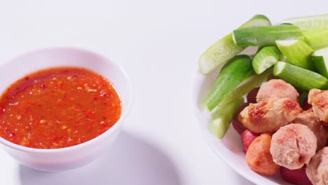 albóndigas fritas y salsa para mojar en un fondo blanco