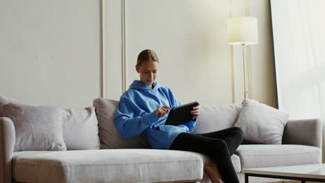 woman using tablet on a couch