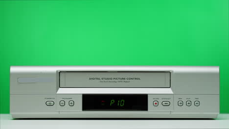 person operating a vintage vcr on green screen