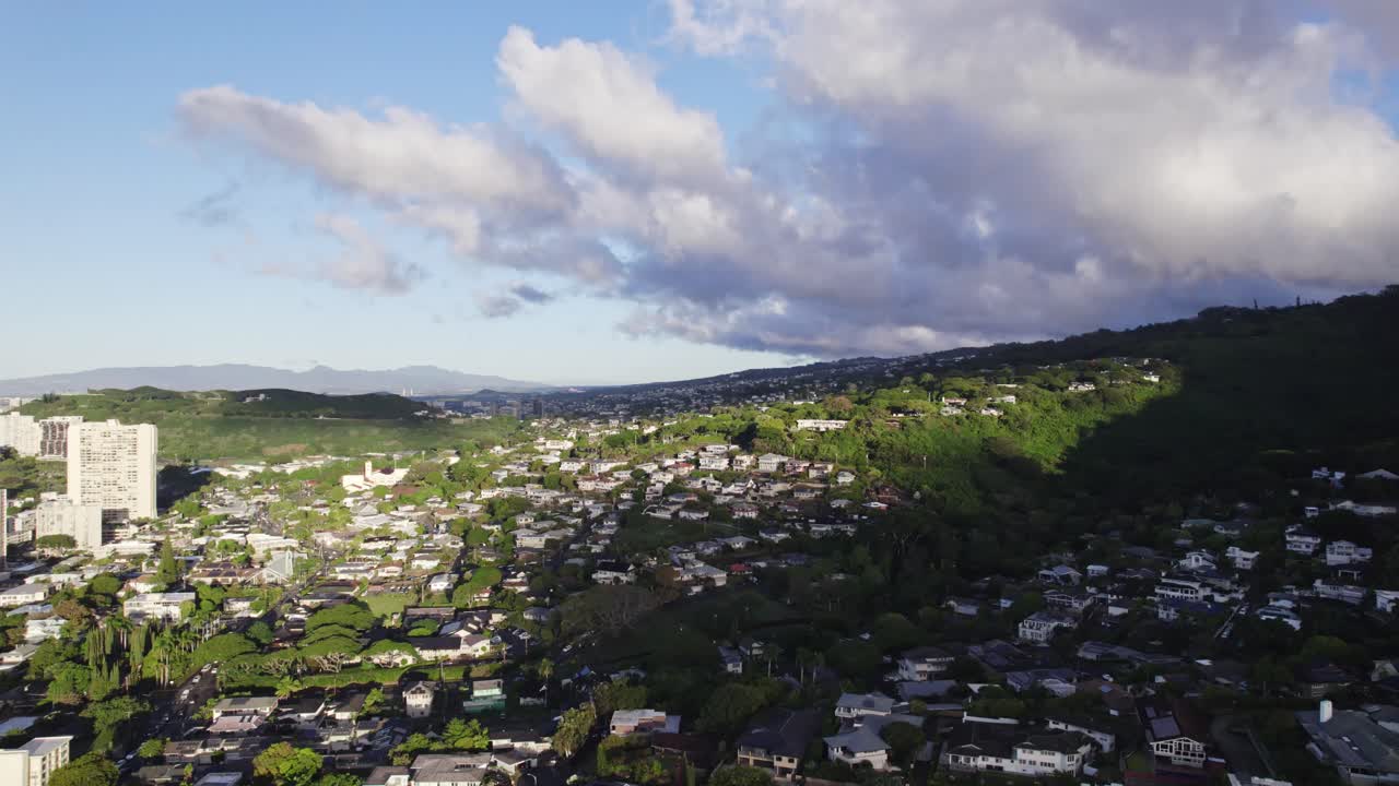 하와이의 호놀루 외의 교외의 정적 은 오후 늦게 산기?? 을 따라 지어진 주택과 함께 마을의 일부 구름을 그늘고 있습니다.