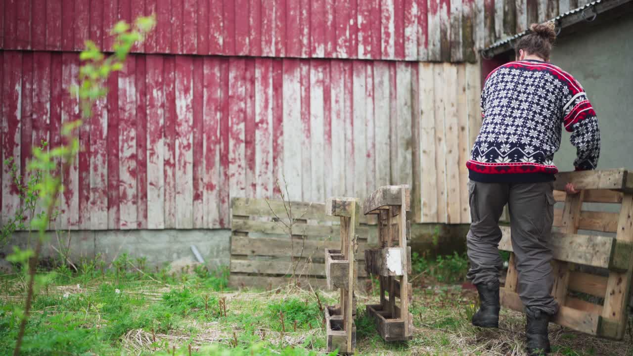 뒷마당 에 나무 팔레트 를 들고 있는 사람