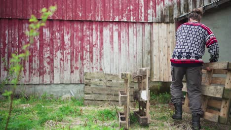 Man-Carrying-Wooden-Pallet-In-The-Backyard