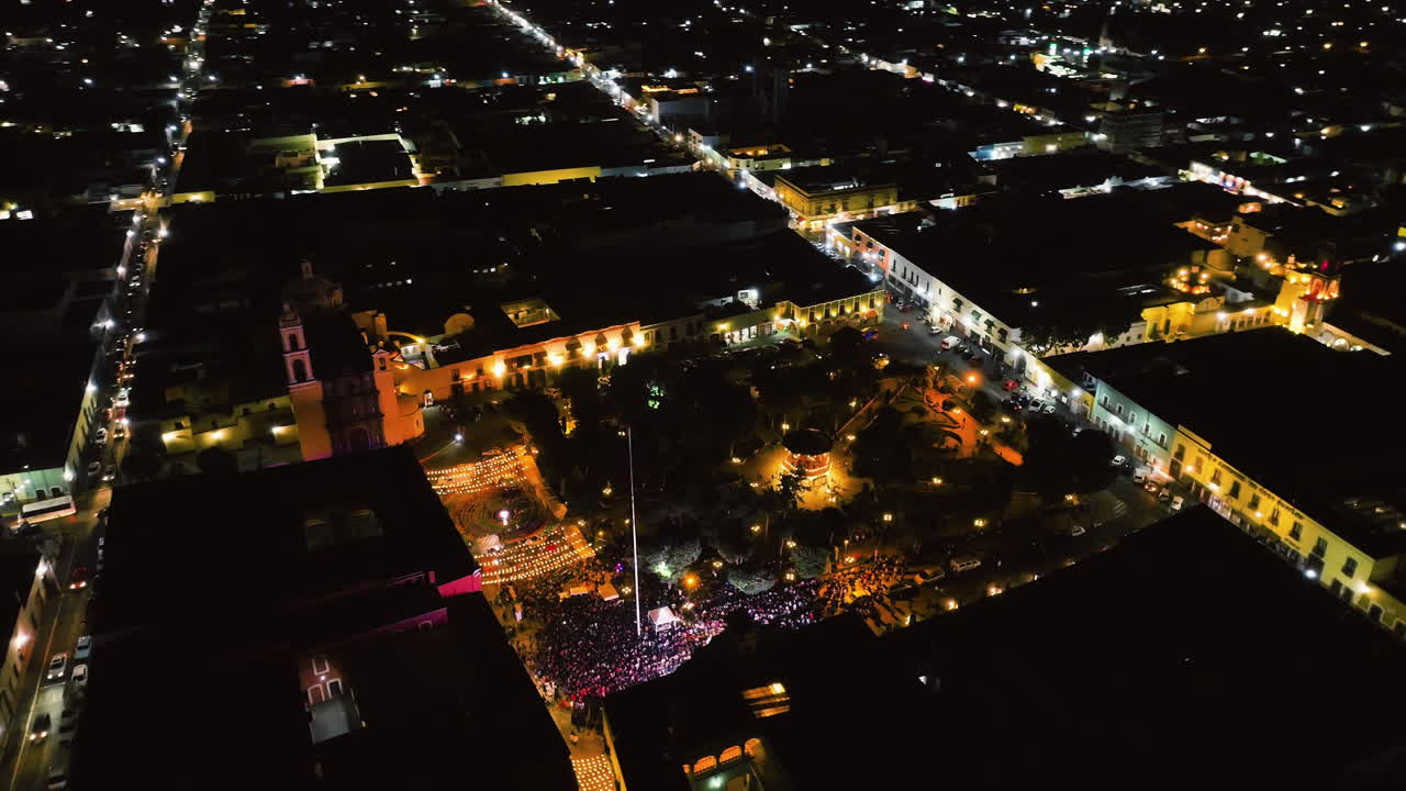 Aerial view around the night lit and crowded Juarez park, in Huamantla, Mexico