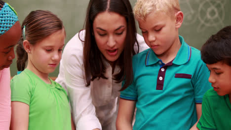 Pupils-an-teacher-looking-at-rock-with-magnifying-glass