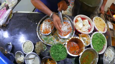 chef prepares an indian dish on a messy and unorganized counter.