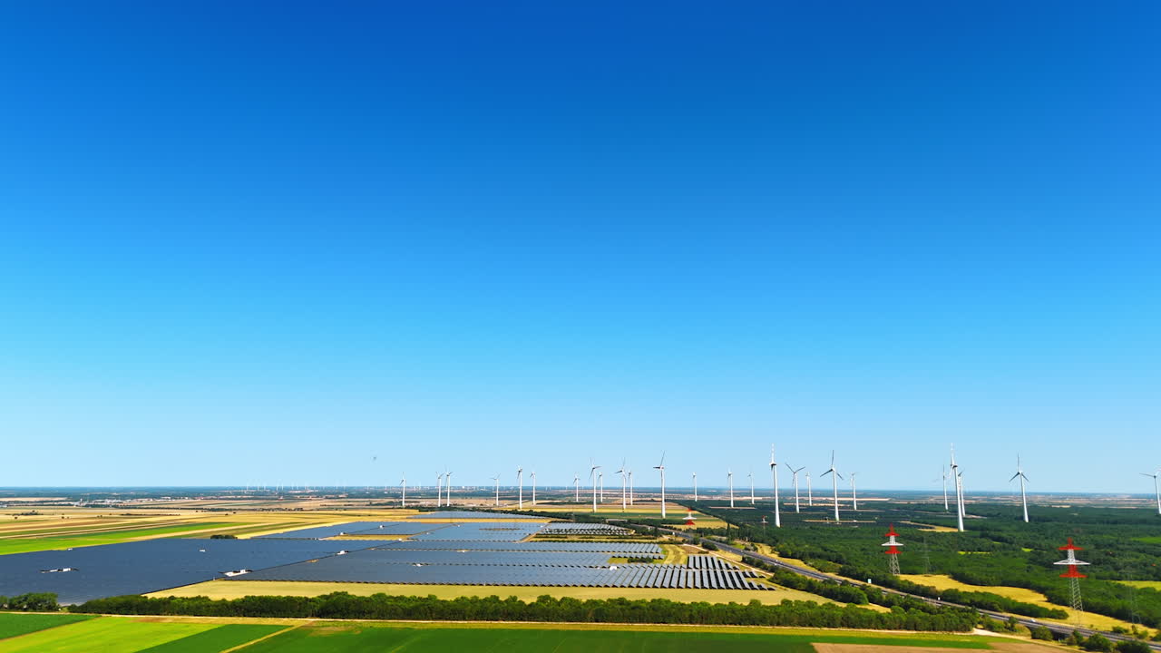 Yellow and green fields with numerous wind mills. Countryside landscape used for wind farms. Aerial view