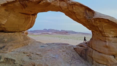 woman exploring the scenic landscape of wadi rum in southern jordan - aerial pullback