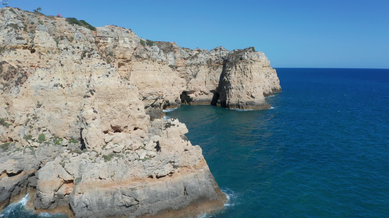 Aerial of rocky cliffside in a blue sea
