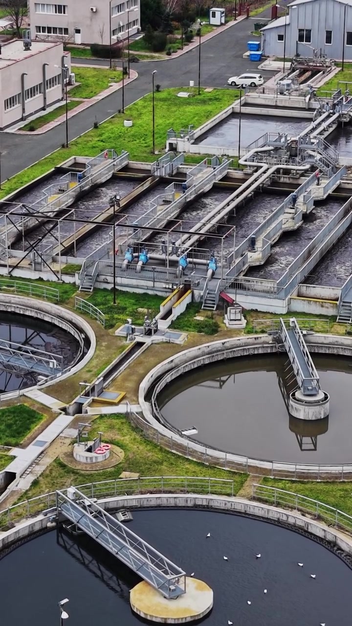 Water treatment facility processing waste in a green area near buildings