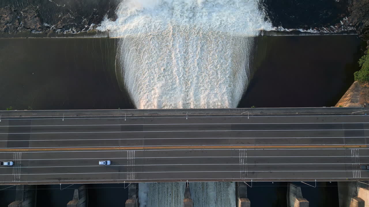 Aerial Drone view of a powerful Water Reservoir running below a highway.