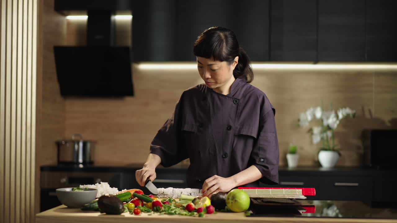 Koki wanita membuat sushi di dapur