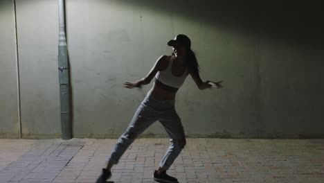 Mujer-Bailando-Joven-Bailarina-Practicando-Movimientos-De-Baile-De-Estilo-Libre-Moderno-Bajo-La-Luz-De-La-Calle-En-La-Ciudad-Por-La-Noche-Con-Sombrero