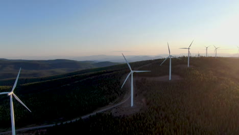 sunsetting behind many wind energy converters