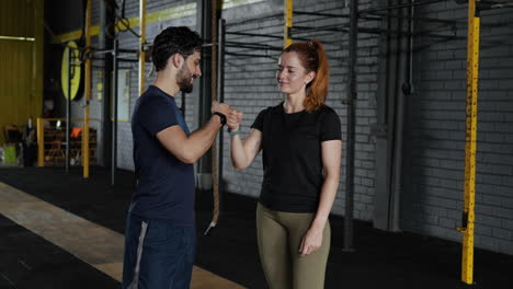 una pareja sonriendo en el gimnasio.