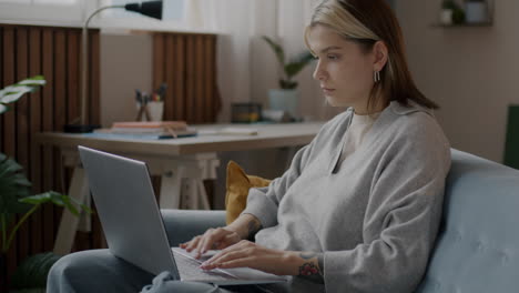mujer joven trabajando en una computadora portátil en casa