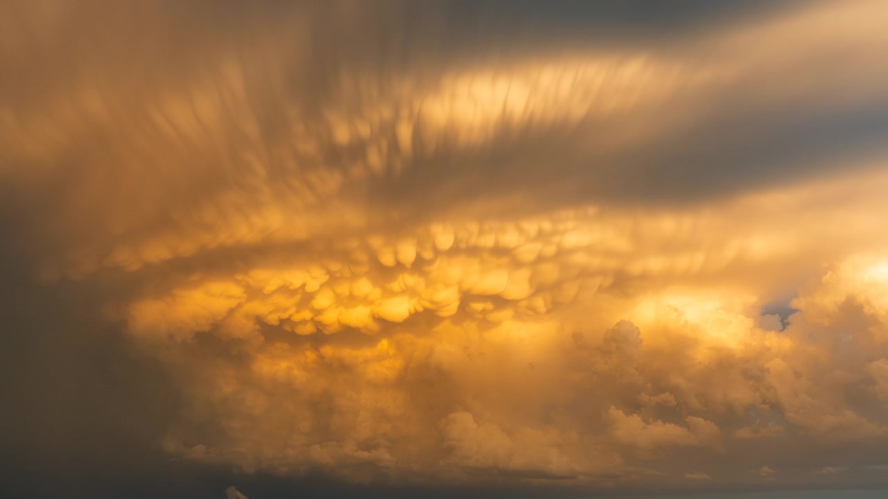 Hell leuchtende Sonnenuntergangswolken am dunklen und stimmungsvollen Abendhimmel.