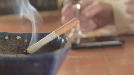 Hands-smoking-cigarette-and-exhaling-in-a-bar-close-up-shot