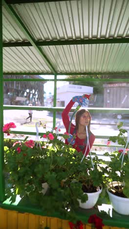 woman watering flowers at a market