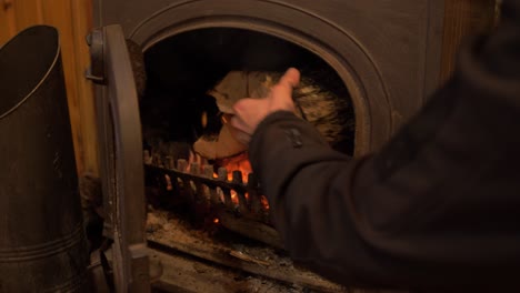 Laden-Des-Holzofens-Mit-Holzscheiten-Mitten-Im-Schuss-4k