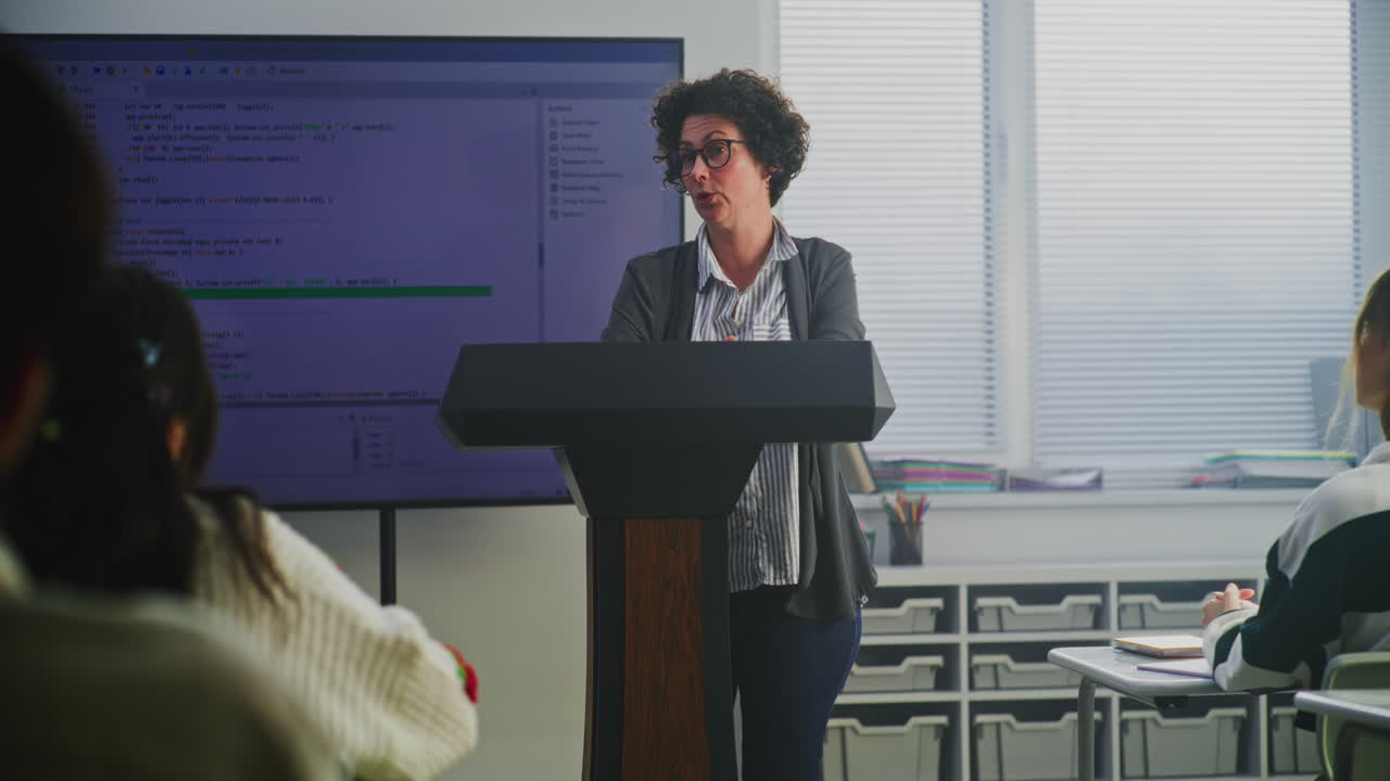 A teacher giving a coding lesson in a classroom