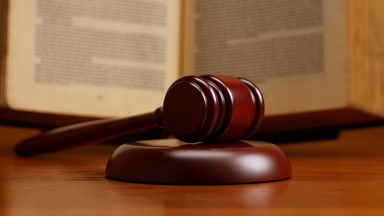 Wooden Gavel On Desk Open Law Book Closeup Of Polished Mahogany Mallet On Sounding Block, Blurred Legal Pages