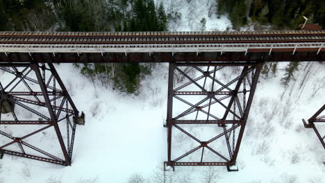 drone flight over a train bridge in the winter with snow on the ground