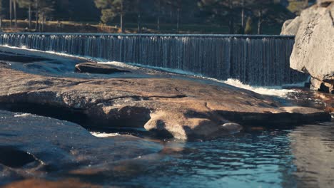 shallow river cascades over the smooth exposed boulders