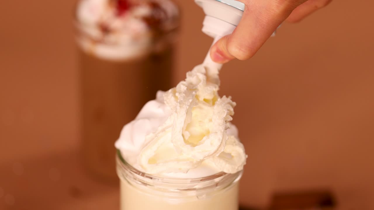 Adding whipped cream to a dessert