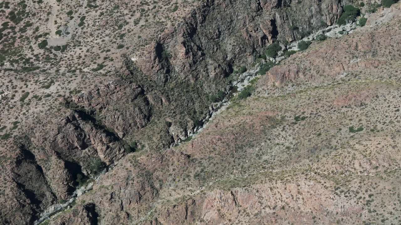 acantilados escarpados y plantas escasas con un pequeño arroyo que fluye a través de él en amaich del valle