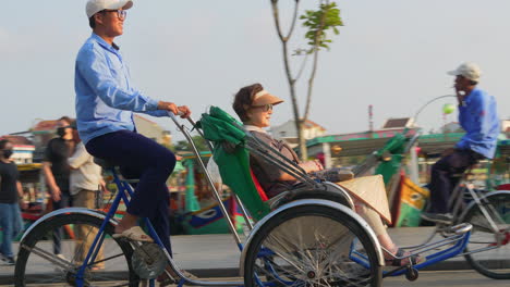 a tracking footage of a tourist on a cyclo rental transpo driving around the city of hoi an in vietnam.