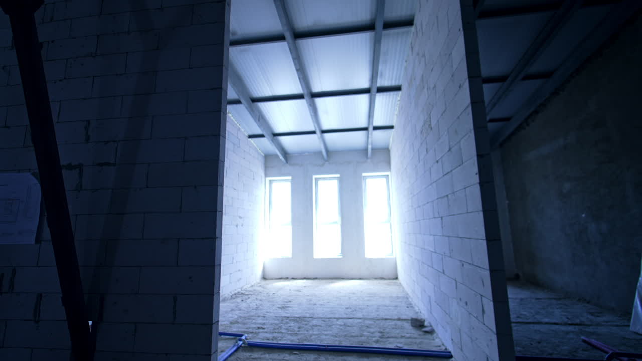 Entering the room with white brick walls and three big windows. Constructing a building.