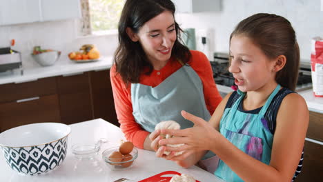 Jewish-girl-preparing-dough-for-challah-bread-with-mother