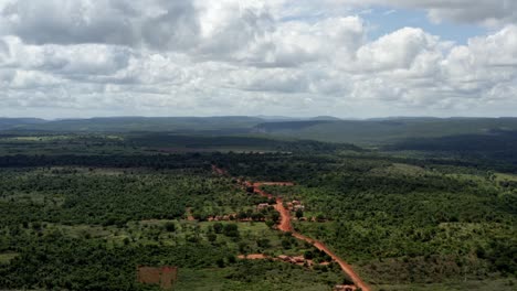 Beautiful-dolly-in-aerial-drone-shot-of-the-Brazilian-countryside-with-a-small-red-dirt-road-in-the-Chapada-Diamantina-National-park-in-Northern-Brazil-and-a-sunny-cloud-filled-summer-day