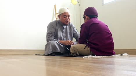indonesian muslim father teaching his son to read the quran