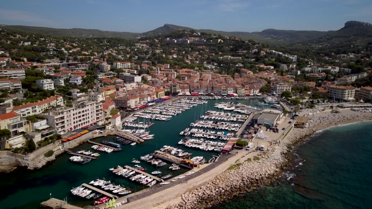 Ripresa con drone in avvicinamento di un grande porto turistico a Cassis, in Francia, in una giornata di sole