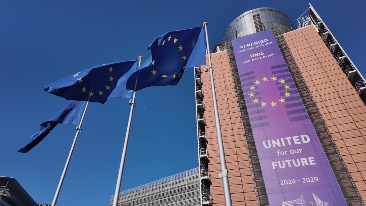 Slow-motion EU flags waving at Berlaymont building in Brussels