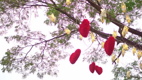 red hearts hanging on a tree with many paper stars and lights twinkling at night. valentine's day concept