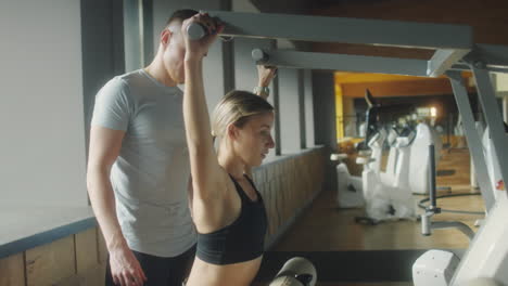 woman training in gym with fitness instructor