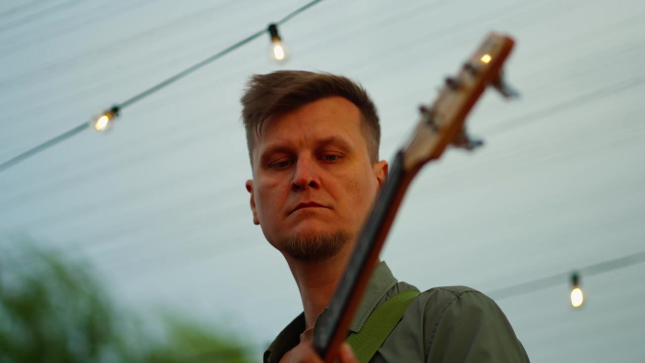 Músico Tocando Baixo Elétrico ao Ar Livre ao Pôr do Sol