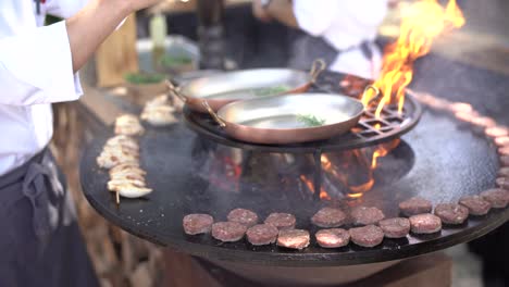 the chef grills meatballs for mini burgers on the grill.