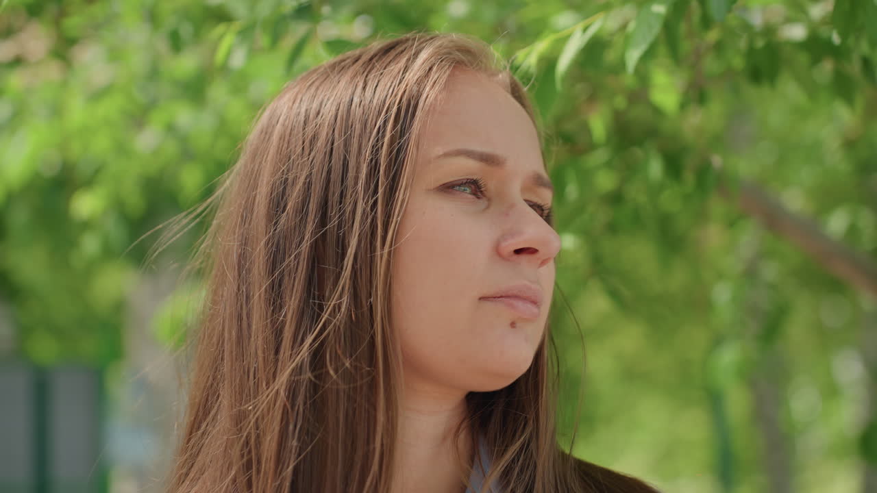 젊고 희망에 찬 미소, 위를 바라보는 편안한 소녀, 자연 경관 속에서 부드러운 미소를 짓는 젊은 여성, 그늘진 공원에서 낙관적인 표정으로 평온한 순간을 즐기는 백인 여성