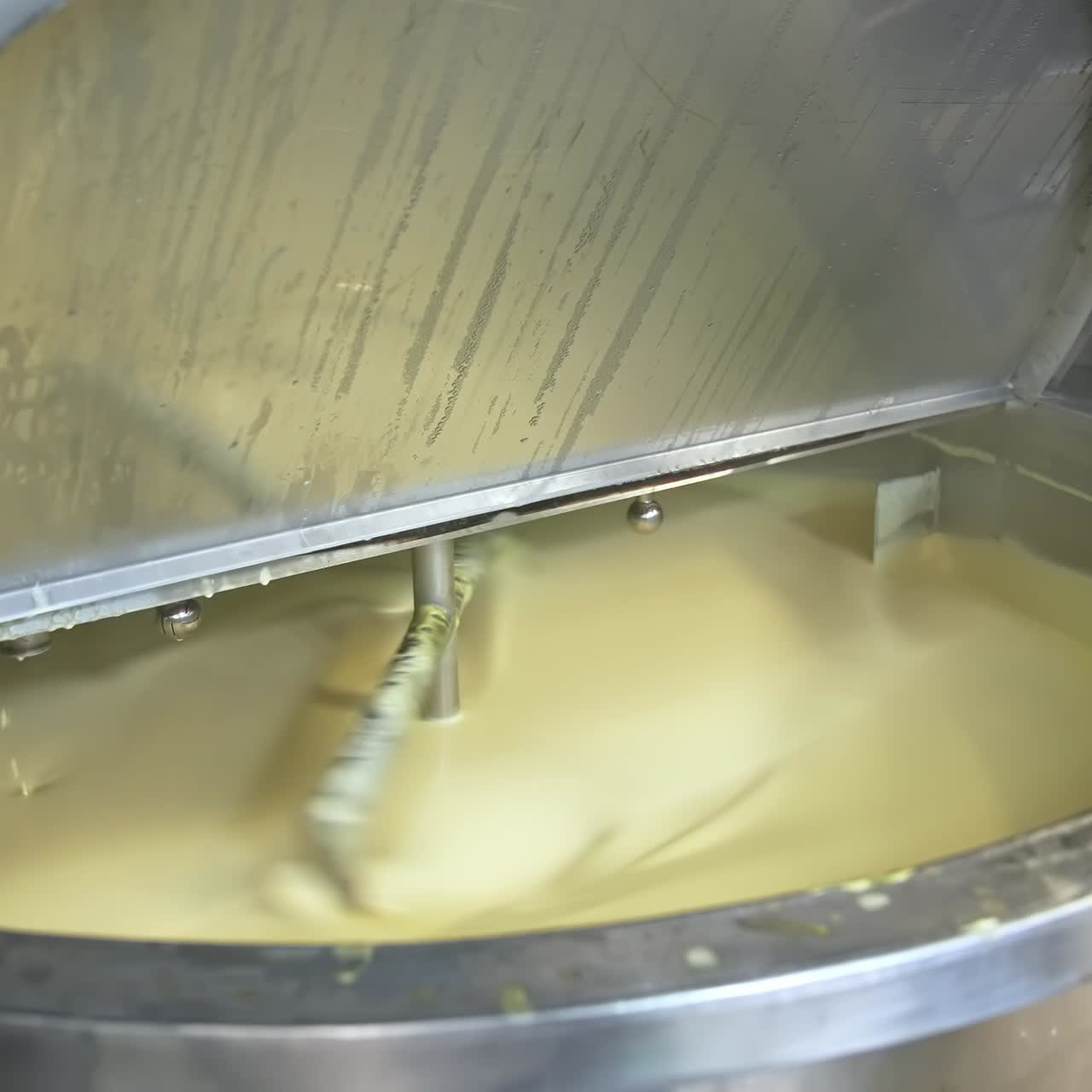 Butter production. Automated equipment mixing dairy product for making butter. Process of making fresh butter on a milk farm. Close-up