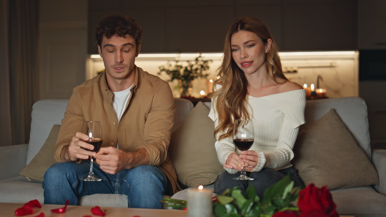 Shying couple having date in cozy evening apartment. Cute pair spending evening