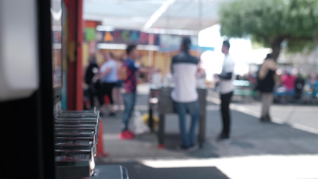Arcade sticker dispenser with people in the background