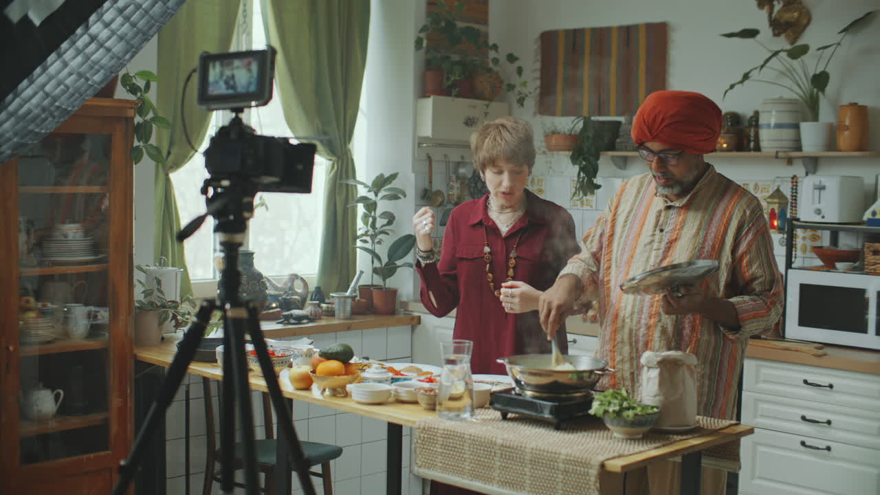 Chef indiano e food blogger che filma un video di cucina con la telecamera in cucina.