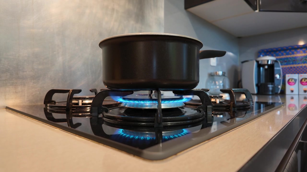 Pentola che si scalda su un fornello a gas con fiamma blu.