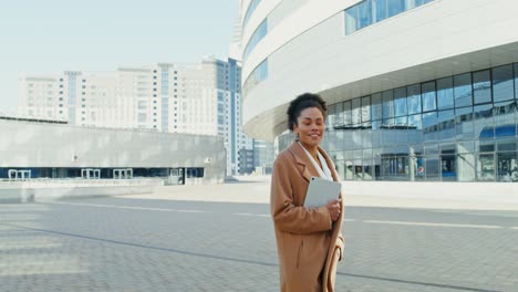 businesswoman walking in city with tablet