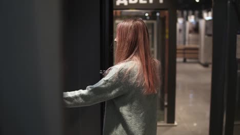 Frau-Wählt-Transparente-Türen-In-Einem-Baumarkt